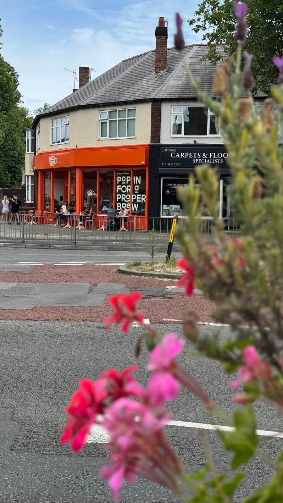 The Dock & Brew corner shopfront with flowers in the foreground