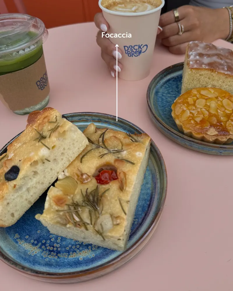 Focaccia and coffee at a pink table