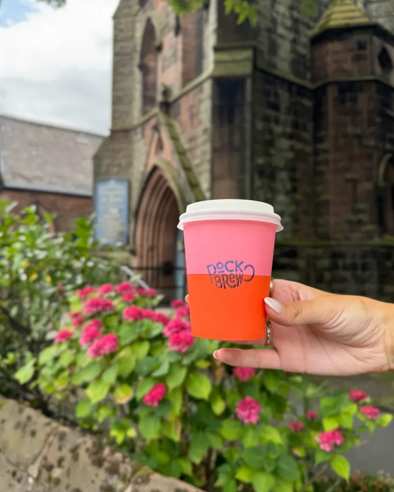 A Dock & Brew cup among the flowers