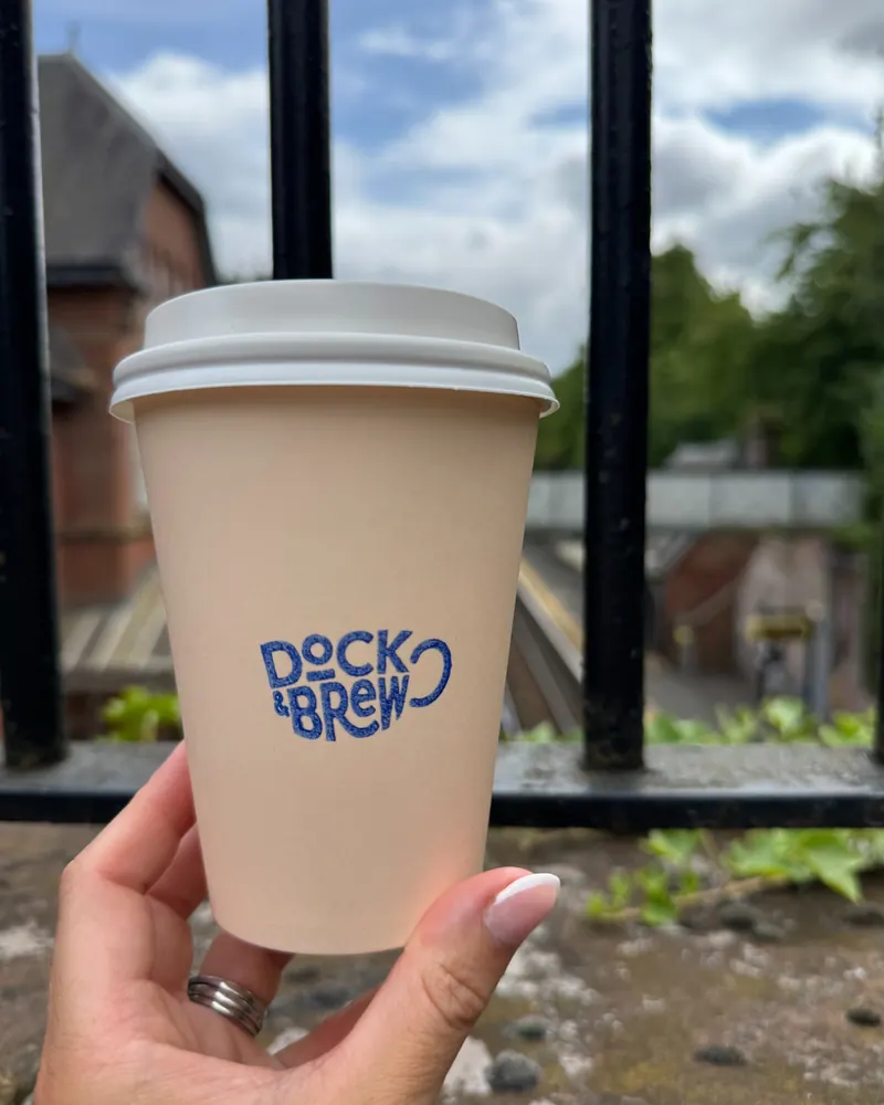A Dock & Brew cup by the water